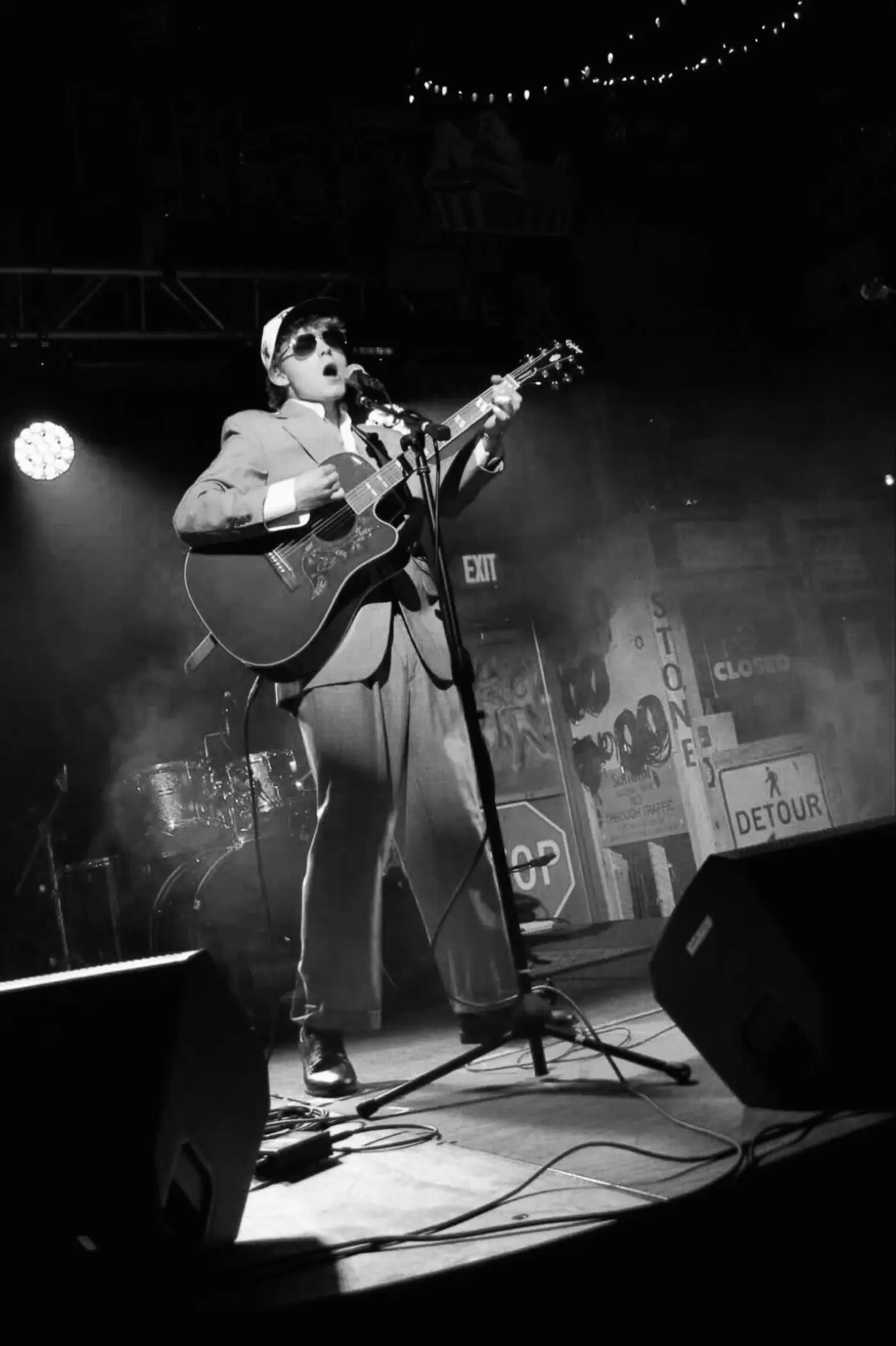 Cameron in a hat and sunglasses on stage