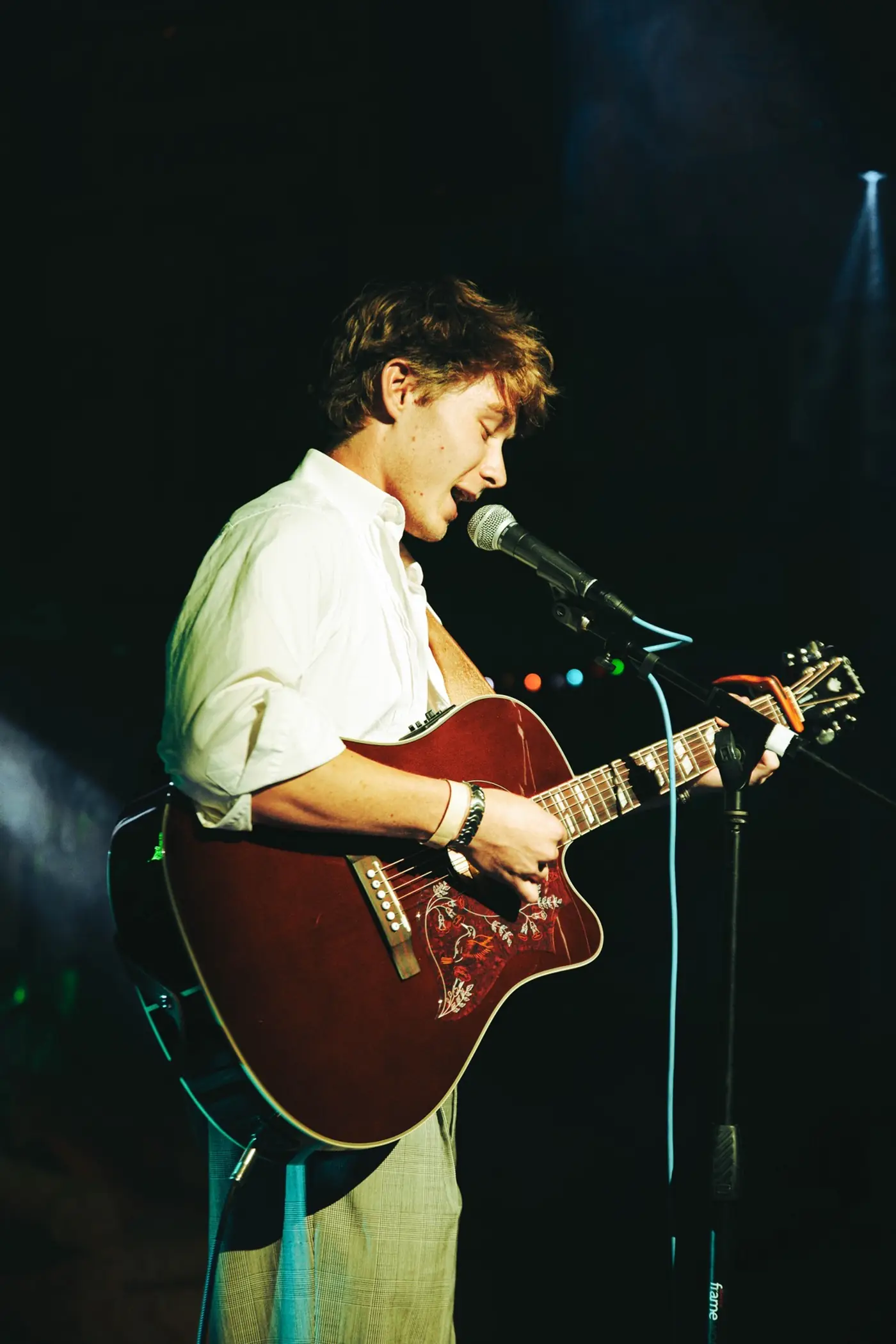 Cameron singing with a red acoustic guitar